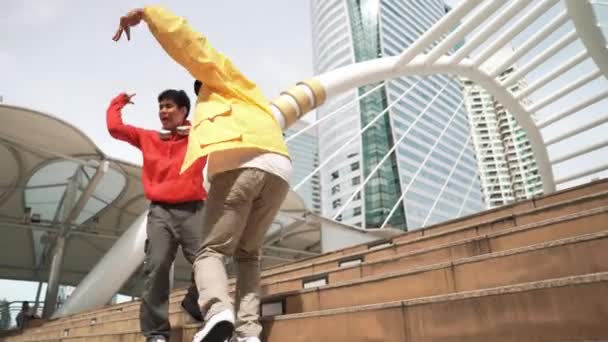 ストリートダンスをしながら階段を歩く多様なヒップスターグループ 魅力的なアジアのダンサーが街の多文化の友人と一緒に踊っています フリースタイル ライフスタイル アウトドアスポーツ 2024 スプライトリー — ストック動画