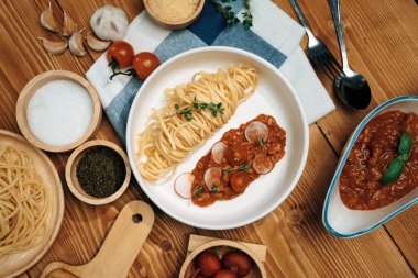 Lezzetli yiyecekler, ev yapımı spagetti, kıymalı domates sosu ve fesleğen fırlatma elementleri, şef masası dekoratif baharatlarla servis ediliyor. Varsayım.