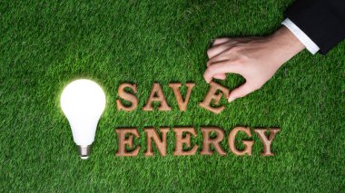 Çevre dostu enerjiyi ve sürdürülebilir Dünya için CO2 emisyonunu azaltmak için sınırlı enerji tüketimini teşvik etmek amacıyla biyofili yeşil çimen arka planı hakkında ECO bilinçlendirme kampanyasında ahşap alfabeyi elle düzenleyin. Gyre