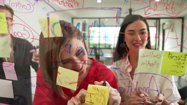通过在玻璃板现代会议室写下五彩缤纷的贴纸 创意商务团队集思广益 分享创业计划的营销理念 一起工作 纯洁无瑕 — 图库视频影像