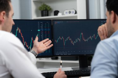 Hisse senedi tüccarları, iki bilgisayar ekranını değerli ve güncel ticaret dinamiklerini dakika dakika karşılaştırmak için kullanarak araştırma piyasası borsası veritabanında gerçek zamanlı olarak tartışıyorlar. Satılabilir.