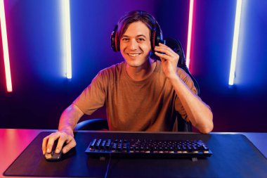 Kazanmak için çevrimiçi oyun oynayan akıllı flama makinesinin sunucu kanalı, neon ışıklı odada seçilen takım yarışması için izleyicilerle birlikte canlı yayında canlı yayında kulaklık takıyor. Bireysel.