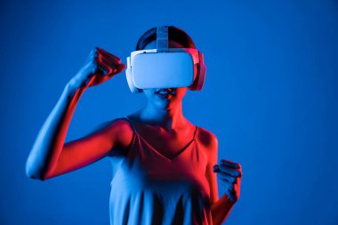 VR kulaklık takan zeki bir kadın metaevrene bağlanıyor, gelecekteki siber uzay topluluğu teknolojisi. Duruş kontrol oyuncusunu yumruklayan zarif bir kadın dövüş oyunları oynuyor. Halüsinasyon.