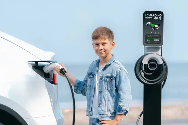 Mały Chłopiec Ładujący Ekologiczny Elektryczny Samochód Stacji Ładowania Podróż Samochodem — Zdjęcie stockowe