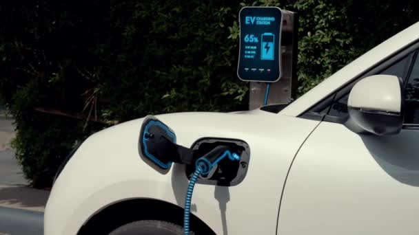 自然緑の駐車場のエコクリーンエネルギー充電ステーションから未来的なスマートEv充電器によって電気自動車の充電バッテリー 代替エネルギーを使用した未来的な環境に優しい電気自動車 Peruse — ストック動画