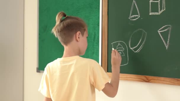 白种人精力充沛的聪明男孩站在黑板前在教室里画画 以表达和发展想象力 在美术课上吸引小学生在黑板上写作 教育学 — 图库视频影像