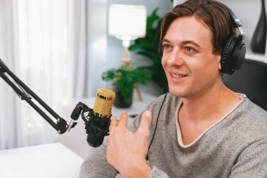 Sunucu kanalı, gülümseyen akıllı yayıncı kaydı, senaryosu ve akıllı telefonuyla sosyal medyada sohbet programı, kulaklık takarak modern ev stüdyosundaki video flamalarını kaydediyor. Bireysel.