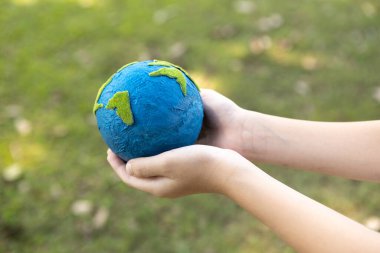 Dünya gezegenini ESG ilkesi ve çevre dostu enerjisiyle daha parlak bir gelecek için Dünya günü olarak el ele tutuşan genç çocuklar. Döngü