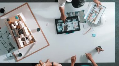 İnşaat mühendisi ekibinin tablet görünümlü ve bina tasarımı planlayan en iyi görüntüsü. Proje planına bakan mimar, proje planı ve ev modeliyle toplantı masasında yatırımcılara sunum yapıyor. Hizalama.