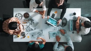 Türbin motoru tasarlamak için çalışan akıllı mühendis takımının yukarıdan aşağıya hava görüntüsü. Profesyonel teknisyen jet motoru yapımını tartışırken motorun bir kısmını işaret ediyor. Hizalama.