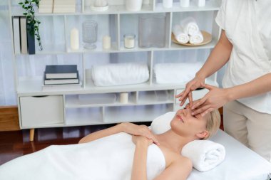 Kafkasyalı kadın stres önleyici kafa masajından ve lüks tatil beldesi ya da otel spa salonundaki modern ışık ortamında yüz güzelliği eğlencelerini şımartmaktan hoşlanıyor. Sessiz.
