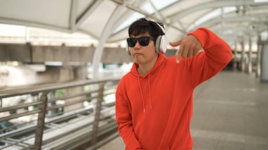 Profesyonel hipster kulaklıktan müzik dinlerken, ritim kutusu da hip hop şarkısına geçiyor. Kulaklık takıp şık kıyafetler giyen break dansçı. Modern yaşam tarzı. Açık hava sporu 2024 Sprightly.