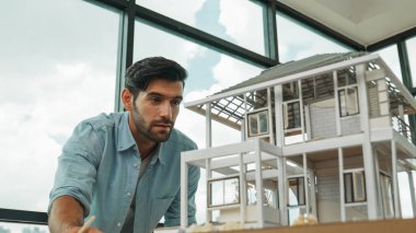 Tasarımlı ev modelini karşılaştıran profesyonel mimar mühendisi. İşadamı gayrimenkul projesine yatırım yapmaya karar verdi. Proje yöneticisi planla karşılaştırarak evi kontrol ediyor. İzleme