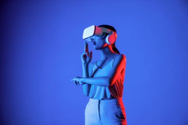 VR kulaklık takan zeki bir kadın metaevrene bağlanıyor, gelecekteki siber uzay topluluğu teknolojisi. Sanal silaha hükmeden zarif bir kadın ciddi ciddi oyun oynuyor. Halüsinasyon.