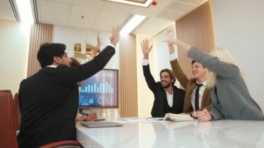 Çeşitli ofis çalışanları, işyerindeki iş sinerjisini ve üretken takım çalışmasını sembolize eden süslü ofis odasında el ele tutuşuyorlar. İş çalışanları arasındaki işbirliği ve birlik.