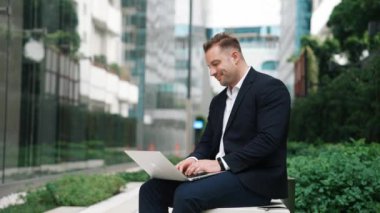 Kafkasyalı proje yöneticisi yeşil şehir merkezinde otururken dizüstü bilgisayardan ve kapalı laptoptan çalışmayı bitirdi. Yetenekli iş adamı rahat bir nefes alıyor ve bilgisayarını kapatıp yorgun gözlerini kapatıyor. Urbane.