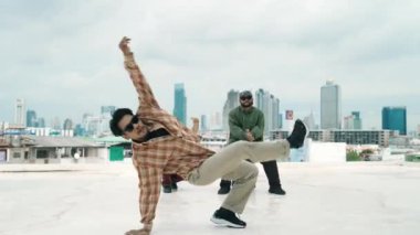 Profesyonel break dans takımı çatıda çok kültürlü arkadaşlar varken break dans alıştırması yapıyor. Genç modern dans grubu hip hop hareketi yapıyor. Tarz, moda, aksiyon. Açık hava sporu 2024 hiphop..