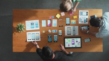 Mobil telefon arayüzü için Ux Ui tasarımı üzerinde çalışan yazılım geliştirici ekibi üzerinde çalışırken yönetici yapışkan bir not alıyor. Prototipi geliştirmek için tartışan ve beyin fırtınası yapan programcı. Cemaat.