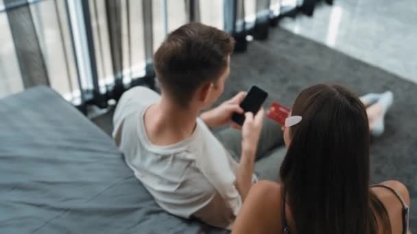 Młoda Para Siedzieć Domu Sypialnia Pomocą Aplikacji Płatności Online Cyfrowy — Wideo stockowe