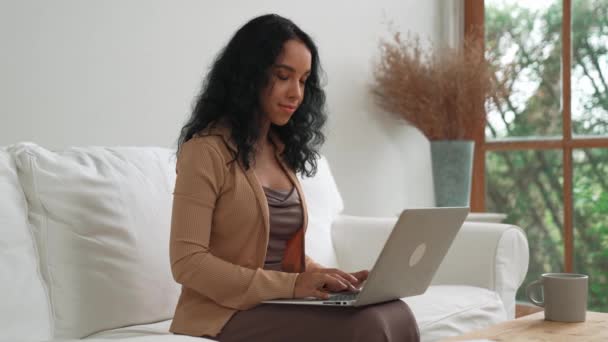 アフリカ系アメリカ人女性は インターネット上で重要な仕事のためにノートパソコンを使用しています 自宅で作業する秘書やオンラインコンテンツ — ストック動画