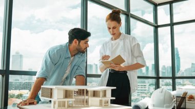 Yetenekli mimar mühendis takımı ev modeli inşaatı hakkında konuşuyor. Akıllı iç mimar paylaşımı, güzel bir iş arkadaşı not alırken bina tasarımından bahsetmek. Tasarım. İzleme