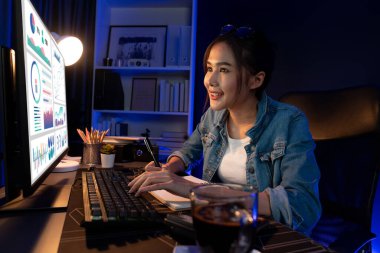 Gülümseyen genç, güzel Asyalı yaratıcı satış hedefi raporunun kar tablosuna bakıyor ve notlar üzerine notlar yazarak neon ışığı gecesinde yeni bir strateji pazarı projesine yatırım yapmayı planlıyor. Taktik.