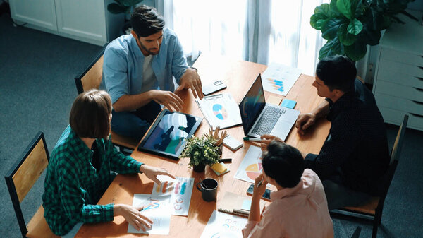 Топ-менеджеры обсуждают идею во время встречи с маркетинговой командой. Менеджер указывает на финансовый график, в то время как коллеги разговаривают с инвестором, используя идею телефона и мозгового штурма. Вызов.