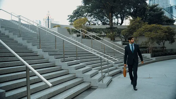Skilled business man walking down stair with a bag and return to home. Closeup of project manager leg getting fired and walk to dormitory. Expert investor with untidy suit holding bag. Exultant.