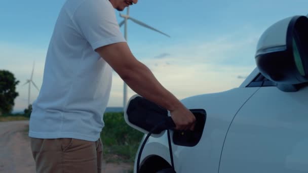 Ασιάτης Άνθρωπος Ένθετο Έξυπνο Φορτιστή Ηλεκτρικό Αυτοκίνητο Που Κινούνται Ανεμογεννήτρια — Αρχείο Βίντεο