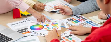 Profesyonel iç mimarın kırpılmış bir görüntüsü, renk örnekleri ve renk paleti belgeleriyle karşılaştırarak iş arkadaşlarıyla renk materyalini tartışıyor. Yaratıcı tasarım konsepti. Değiştirilmiş.