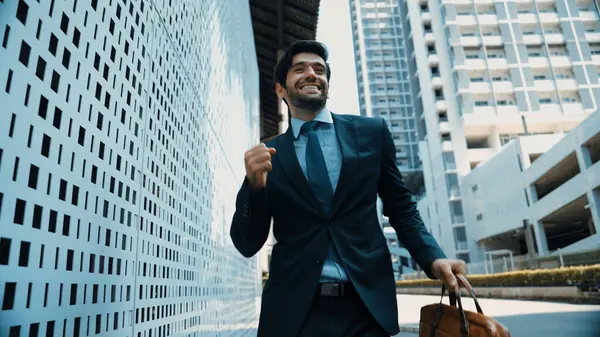 Skilled business man dancing with joyful while walking in city street. Project manger receive a good news, getting promotion, getting a successful job while express feeling of overjoy. Exultant.