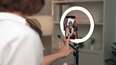 Arka plan etkileyicisi, vlog video gözden geçirme makyaj primi sosyal medya ya da blog kullanarak akıllı telefon yayınıyla canlı çekim yapıyor. İnternetteki pazarlama kaydı için kozmetik stüdyosu ışıklandırması olan kız.