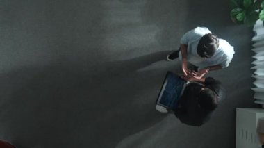 Yöneticinin elinde tablet tutarken yatırımcıyla durduğu ve mali istatistiklere baktığı en düşük bakış açısı. Lider konuşuyor ve tabletteki borsa grafiğinin artması konusunda tavsiyede bulunuyor. Cemaat.