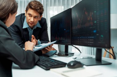 Kağıt raporunda değer istatistik şirketini tartışan iki tüccar dinamik borsa para birimini gerçek zamanlı web sitesi ofisteki bilgisayar ekranlarını çevreledi. Varsayım.