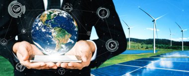 Alternatif enerji ile sürdürülebilirlik gelişimi kavramı. Çevre dostu rüzgar türbini çiftliği ve arka planda yeşil yenilenebilir enerji olan gezegenle insan eli ilgilenir. uds