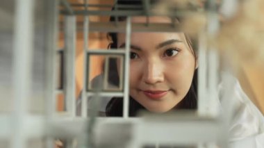 İnşaatı incelerken, profesyonel mimar mühendisinin yüzü ev modelini inceliyor. Proje yöneticisi ev modelini kontrol ediyor. İş tasarımı konsepti. Yüzüne odaklan. Yönlendirici.