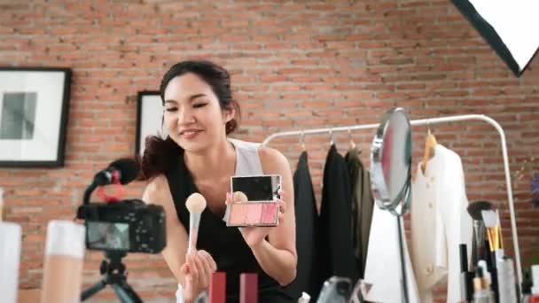 女性インフルエンサーは ライブストリーミングビデオレビュー鮮やかなメイクアップソーシャルメディアやブログを撮影します オンラインでのマーケティングレコーディングセッション放送のための化粧品スタジオ照明を持つ幸せな若い少女 — ストック動画