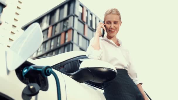 Geschäftsfrau Mit Smartphone Lädt Elektroauto Ladestation Wohnmobilstellplatz Auf Moderner Urbaner — Stockvideo