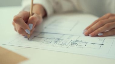 Profesyonel, genç ve güzel mimarın el çizimi, kooperatif iş arkadaşı ev modelini cetvel kullanarak ölçer. Yaratıcı tasarım ve takım çalışması konsepti. Eline odaklan. Tertemiz..