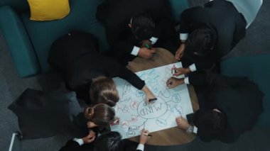 Zihin haritası yazarken bir grup zeki iş adamının beyin fırtınası pazarlama fikrinin yukarıdan aşağı görüntüsü. Yaratıcı ekip, zihin haritasını kullanarak stratejiyi paylaşmak için birlikte çalışıyor. Müdürlük.