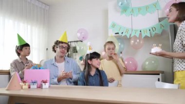 Mutlu kız doğum gününü kutlarken beyaz anne doğum günü pastasını tutarken güzel bir aileyle şarkı söylüyor. Çekici anne pasta getiriyor ve parti şapkası takıp odaya giriyor. Pedagoji.