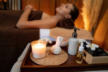 Aromaterapi masajı ambiyansı ya da spa salonu kompozisyon düzeneği bulanık kadınlara odaklı dekor mumları ve spa aksesuarları ile tatil köyü veya otel arka planında keyifli aroma spa masajı yapan. Sessiz.