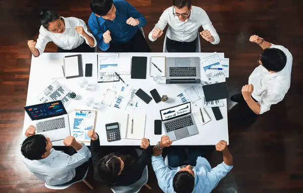 Top view meeting table, excited and happy office worker celebrate after make successful strategic business marketing planning. Teamwork and positive attitude create productive workplace. Prudent