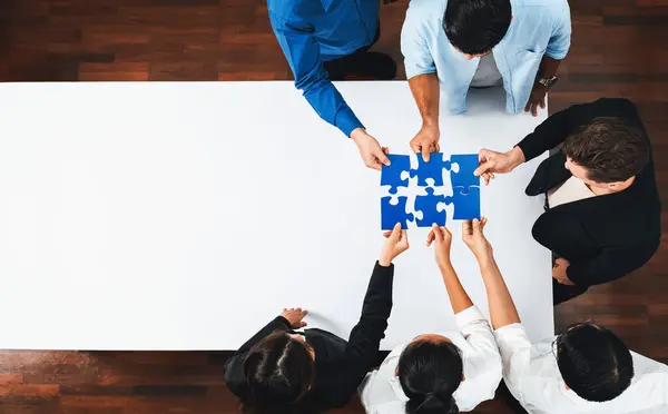 Top view panorama banner of business team joining jigsaw puzzle together over meeting table symbolize business partnership and collective unity teamwork in problem solving solution. Prudent