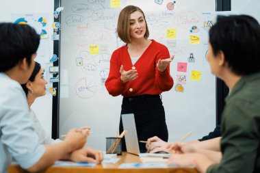 Profesyonel çekici kadın lider, modern iş toplantı odasında beyin fırtınası zihin haritalama istatistikleri ve renkli yapışkan notlar kullanarak yaratıcı pazarlama planını sunuyor. Tertemiz..