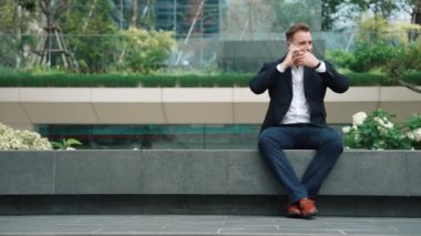 Kafkas işadamı, yatırımcılarla pazarlama stratejisi hakkında konuşurken parkta oturuyor. Mutlu akıllı yönetici, artan satışlar ya da Eko City 'de başarılı bir proje arıyor. Yaşam tarzı. Urbane