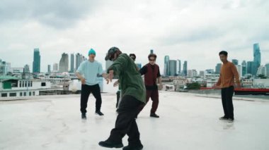 Profesyonel break dans takımı çatıda çok kültürlü arkadaşlar varken break dans alıştırması yapıyor. Genç modern dans grubu hip hop hareketi yapıyor. Tarz, moda, aksiyon. Açık hava sporu 2024 hiphop..