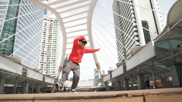 Hipster Asia Mengenakan Headphone Menunjukkan Langkah Kaki Saat Melompat Kota — Stok Video