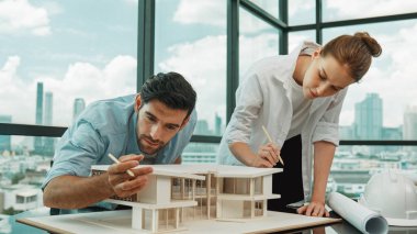 Kooperatif mimar mühendis ekibi kalem kullanarak ev modelini ölçmek için birlikte çalışıyor. Başarılı bir Kafkas iç mimari tasarım ekibi mimari model yapısını inceliyor. Tasarım. İzleme