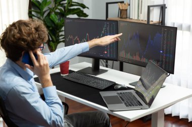 Başarılı genç yatırımcı, akıllı telefondan iş ortağına Dinamik Finansal Değişim Yatırım Dizüstü bilgisayarı ile modern ofisteki mevcut pazar grafiğinde gerçek zamanlı arıyor. Toplayıcı.